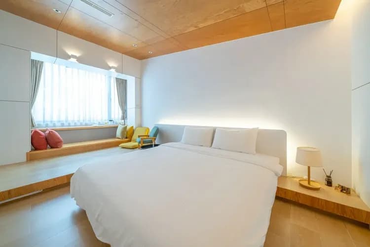 2樓白色控房型｜雙人床鋪搭配背光設計，創造溫潤柔和的空間氛圍。