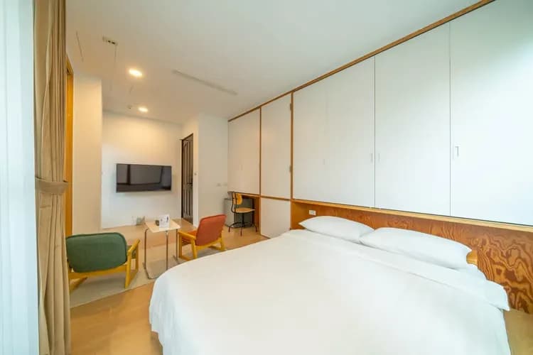 2/3樓文青房型｜雙人房配有電視與雙椅小茶几，讓旅人在空間中輕鬆轉換心情，感受自在的片刻。