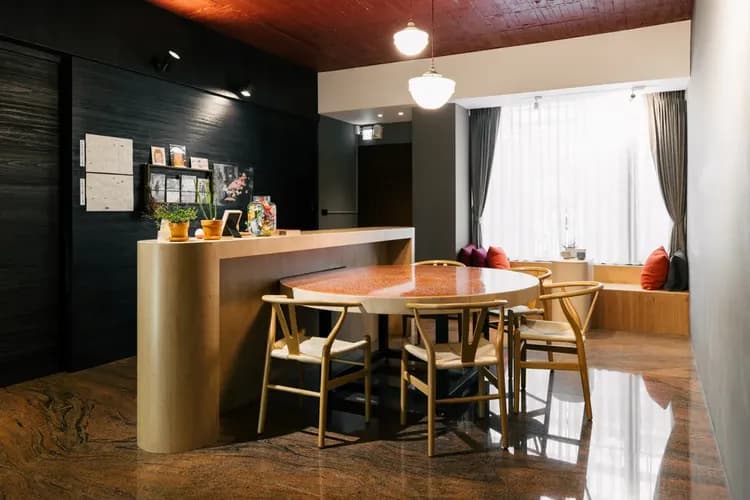 1樓公共空間｜紅色大圓桌搭配窗邊座位，適合多人圍爐聚會與輕鬆聊天。