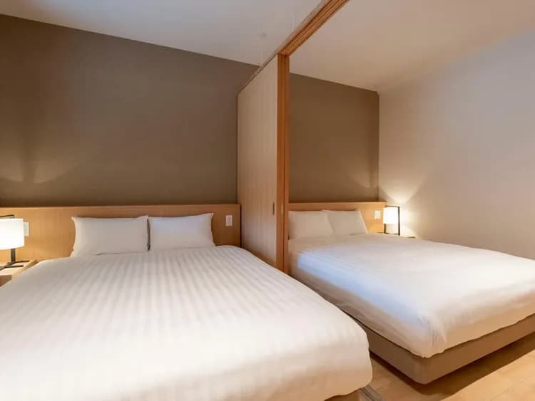 【102・103】寝室／間仕切りにより、多様な滞在スタイルに対応できるクイーンベッドの寝室