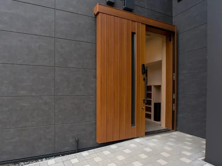 【玄関】車いすやベビーカーなどの利用に配慮した、引き戸形式の大きい入口。