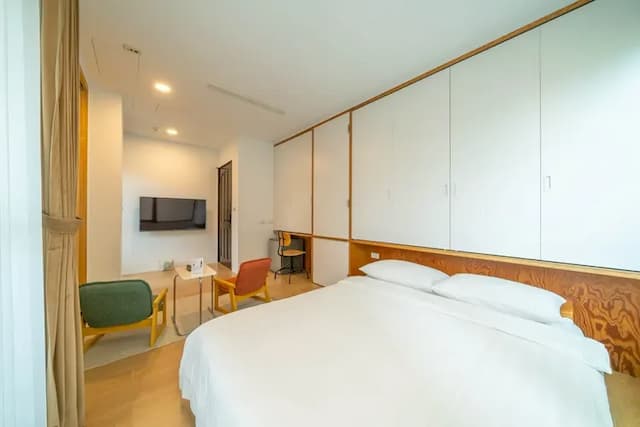 雙人房配有電視與雙椅小茶几，讓旅人在空間中輕鬆轉換心情，感受自在的片刻。