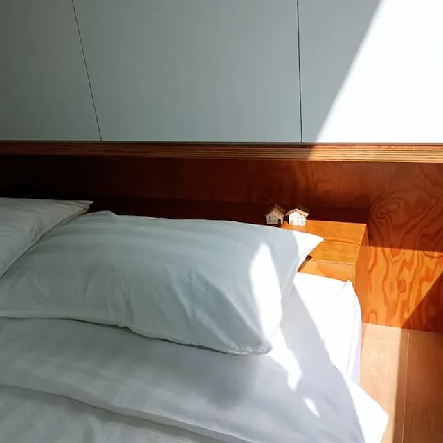 溫潤木牆與可愛擺飾點綴床邊，為空間注入生活的溫度與細節感。