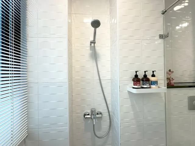 淋浴空間配有置物架與茶籽堂備品，讓每一次沐浴都成為放鬆儀式。