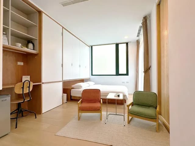 房內全景一覽，雙人床與收納設計井然有序，展現日常的溫柔秩序。