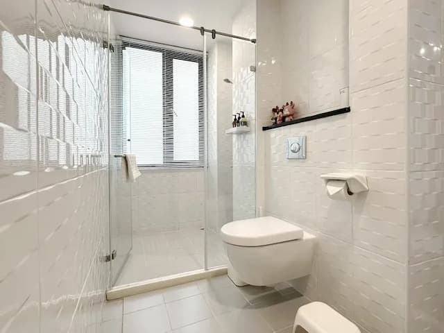 玻璃門淋浴間搭配淺色磁磚，清新明亮，提升每一次沐浴的質感。