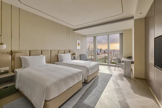 房內空間約13坪大，客房採光良好，沿著大面玻璃自然灑入的陽光呈現和諧氛圍，採用現代簡約的設計語彙，床型可搭配一大床或兩小床的組合選擇，讓你享受豐富多樣的起居生活美感。