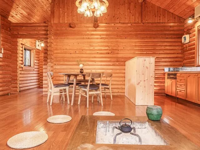 ・【リビング】ログハウスならではの一面の丸太、家具も木製のものが中心となっております