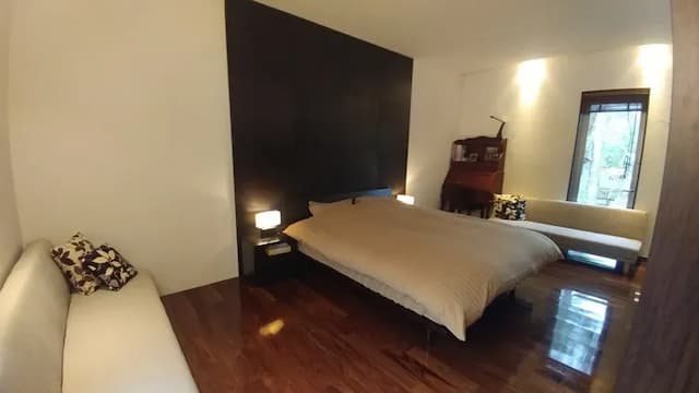 リビングスペースとパーテーションで区切ったベッドスペース｡クイーンサイズのベッドの両側にソファーベッドを設置