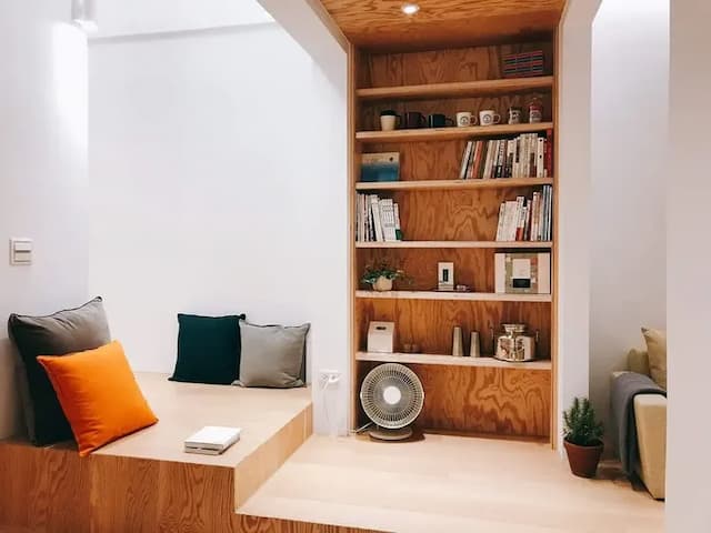 房內設有兩人座沙發與木作書櫃，為您打造放鬆閱讀與對話的溫暖空間。