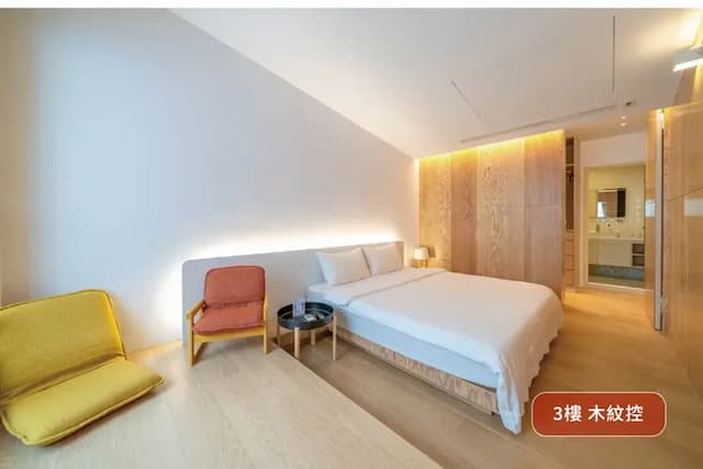 3樓木紋控房型｜大地色木紋與柔光牆面交織溫潤氛圍，床邊角落適合展開慵懶的午後時光。