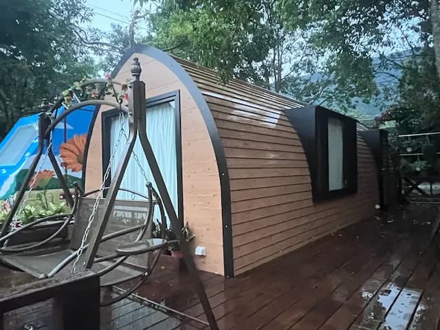 圓弧木屋造型結合玻璃窗與戶外吊椅，沉浸在山林氛圍中，白天享受日光灑落，夜晚靜聽蟲鳴，是放鬆身心的理想之地。