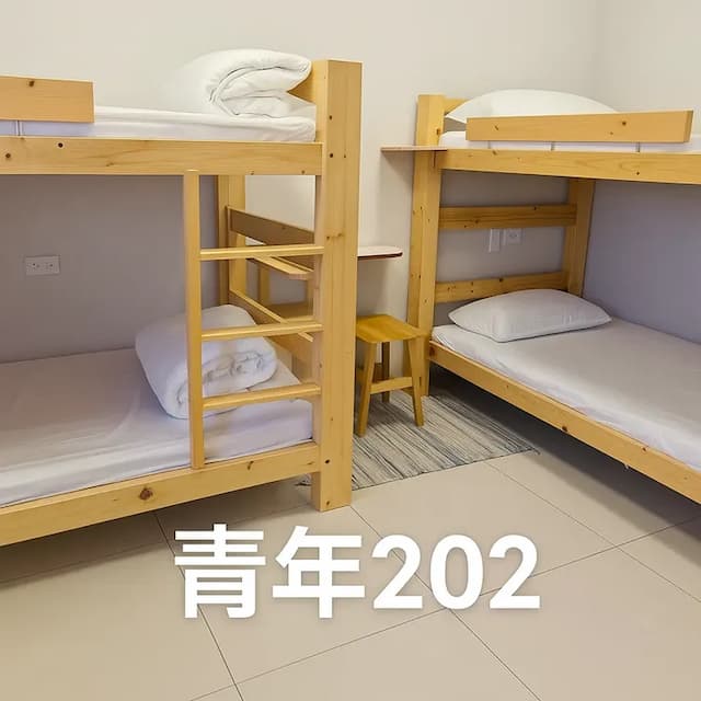 溫暖木質上下舖設計，床墊柔軟舒適，附枕頭與棉被，適合家人、朋友或背包客同住。